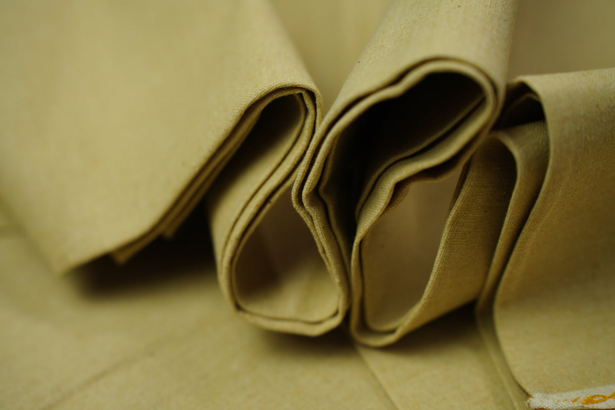 Close-up of folded desert sand fabric with a soft, slightly textured surface.