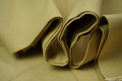 Close-up of folded desert sand fabric with a soft, slightly textured surface.